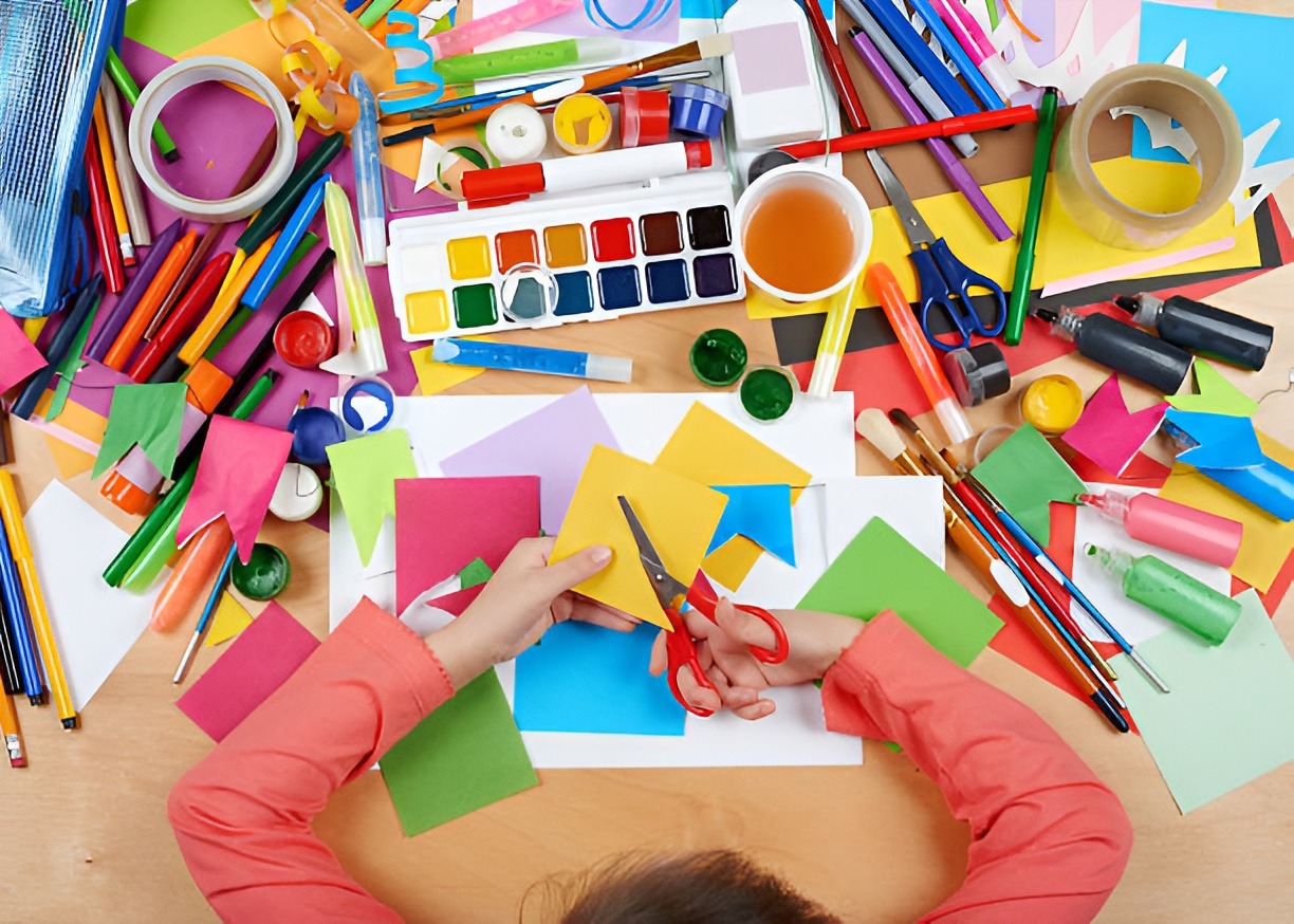 Child cut applique top view. Artwork workplace with creative accessories. Flat lay art tools for painting.